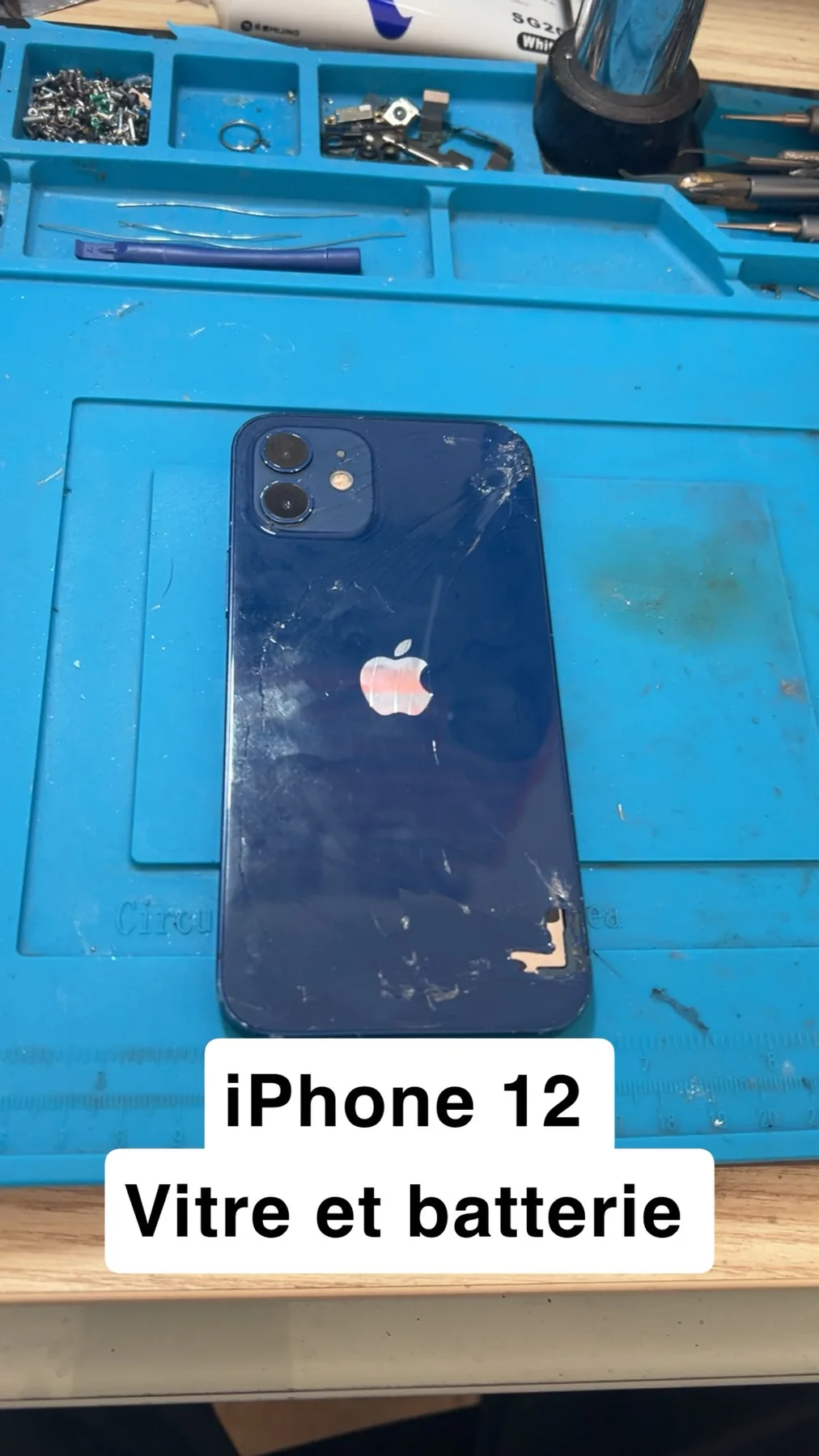 Photo réelle d’un iPhone avec vitre arrière endommagée avant réparation chez Badiphone à Lille.