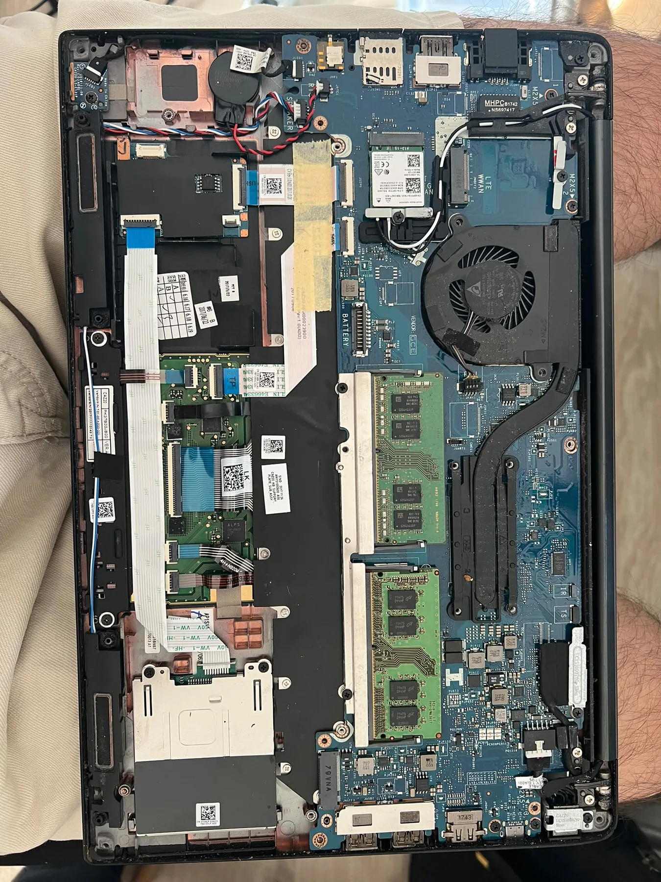 Photo réelle d’un PC portable démonté montrant sa carte mère pendant un diagnostic chez Badiphone à Lille.